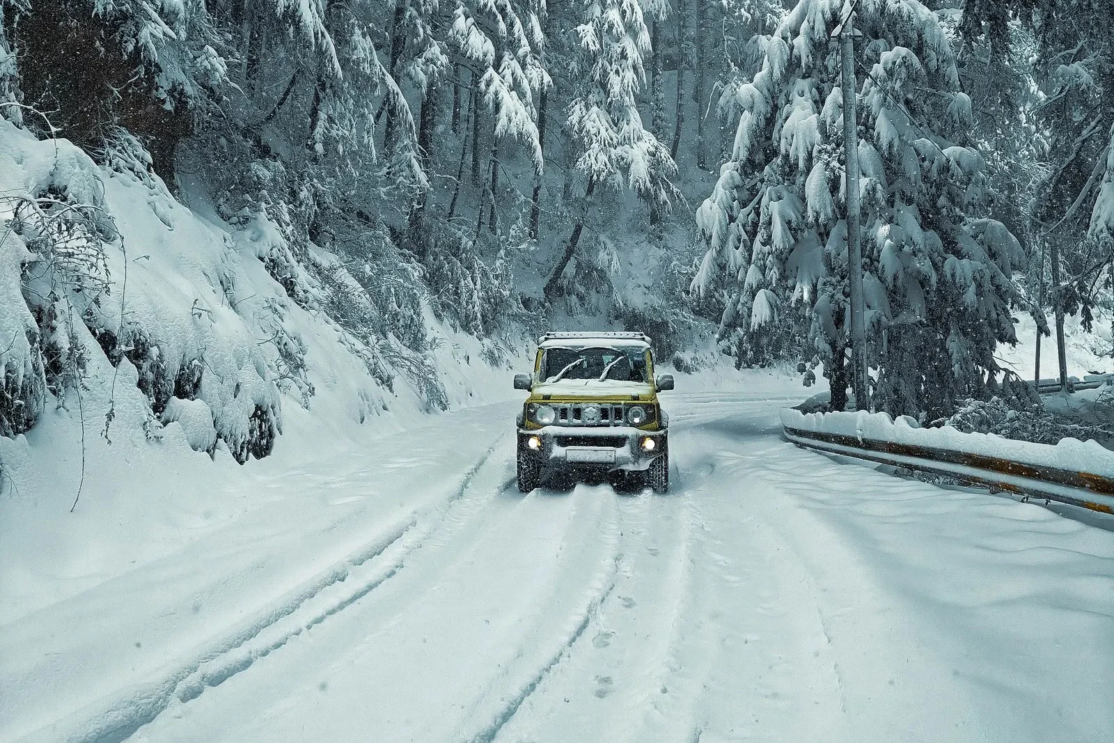 An off-road vehicle driving a snow-covered forest road