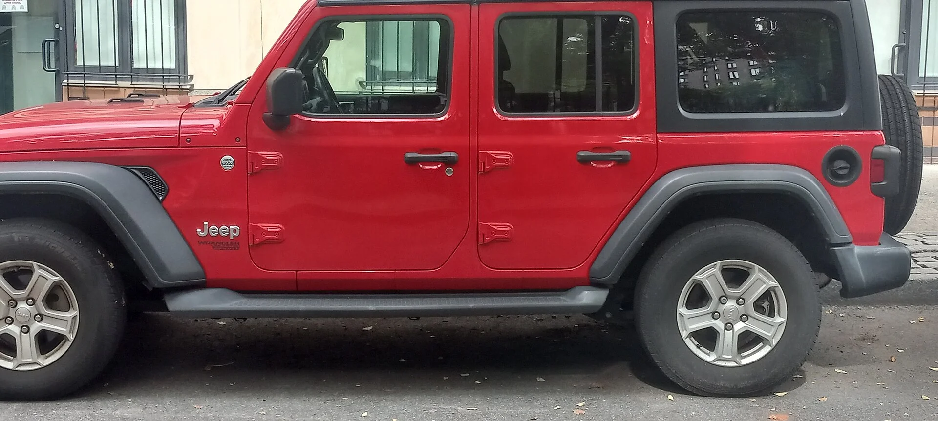 A Jeep Wrangler (JL generation) parked on a city street